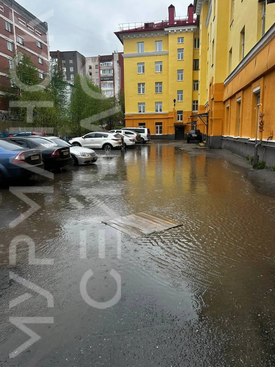 Из‑за продолжительных дождей, отсутствия ливнёвки и плохого асфальта во дворе дома на улице Шмидта, 17 собрался крупный водоём — жители отмечают, что пройти по двору можно только в резиновых сапогах.
