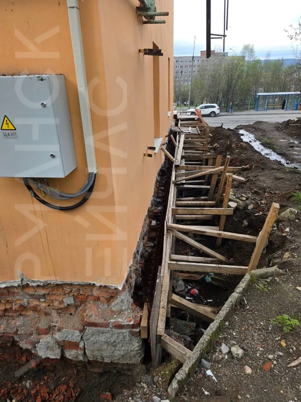 Фасад выглядит аккуратно, но с прошлого года у дома раскопан фундамент: талые воды уходят под здание, а внутри — сырость и запущенные подъезды.