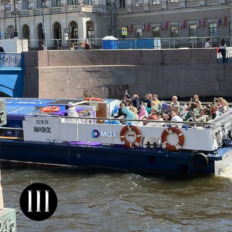 Теплоход «Миканос» курсирует по рекам и каналам Санкт‑Петербурга с символикой госмессенджера «Макс», предлагая бесплатные прогулки при условии записи через сервис; среди ведущих — Ксения Собчак, историк Егор Яковлев и писатель Андрей Кивинов.