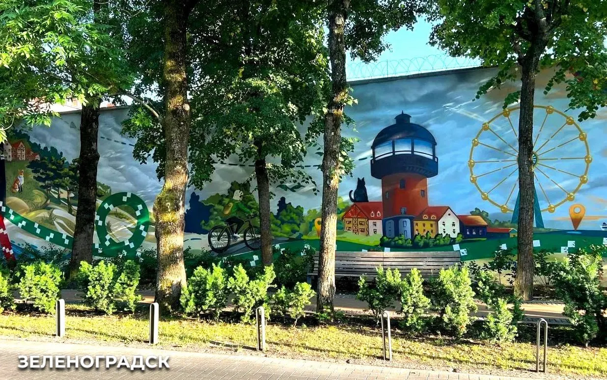 Художник Кирилл Гейнц создал роспись площадью более 100 квадратных метров, соединяющую символику 80-летия Калининградской области с узнаваемыми деталями Зеленоградска: Балтийское море, Куршскую косу, городскую архитектуру и велодорожку.
