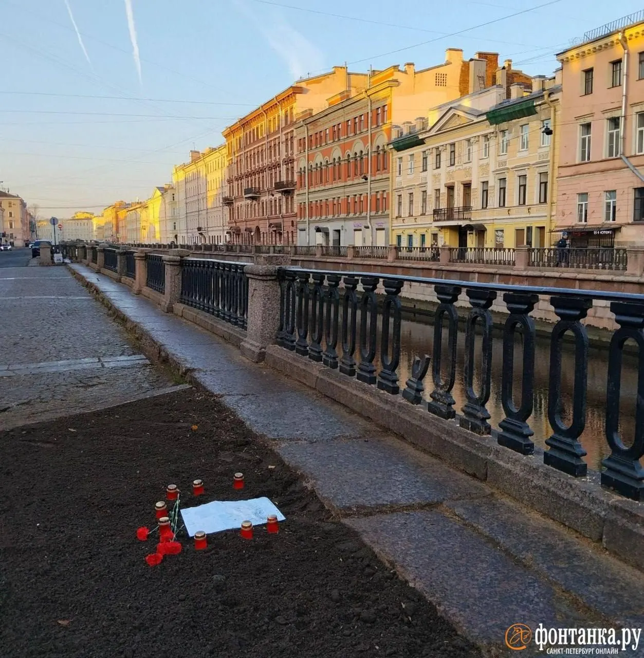 На месте срубленного дерева появился памятник-мемориал: свечи, цветы и надпись, рассказывающая историю дерева.