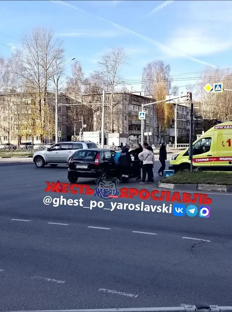 На месте работает скорая помощь; на дороге лежат электросамокат и рюкзак доставки.