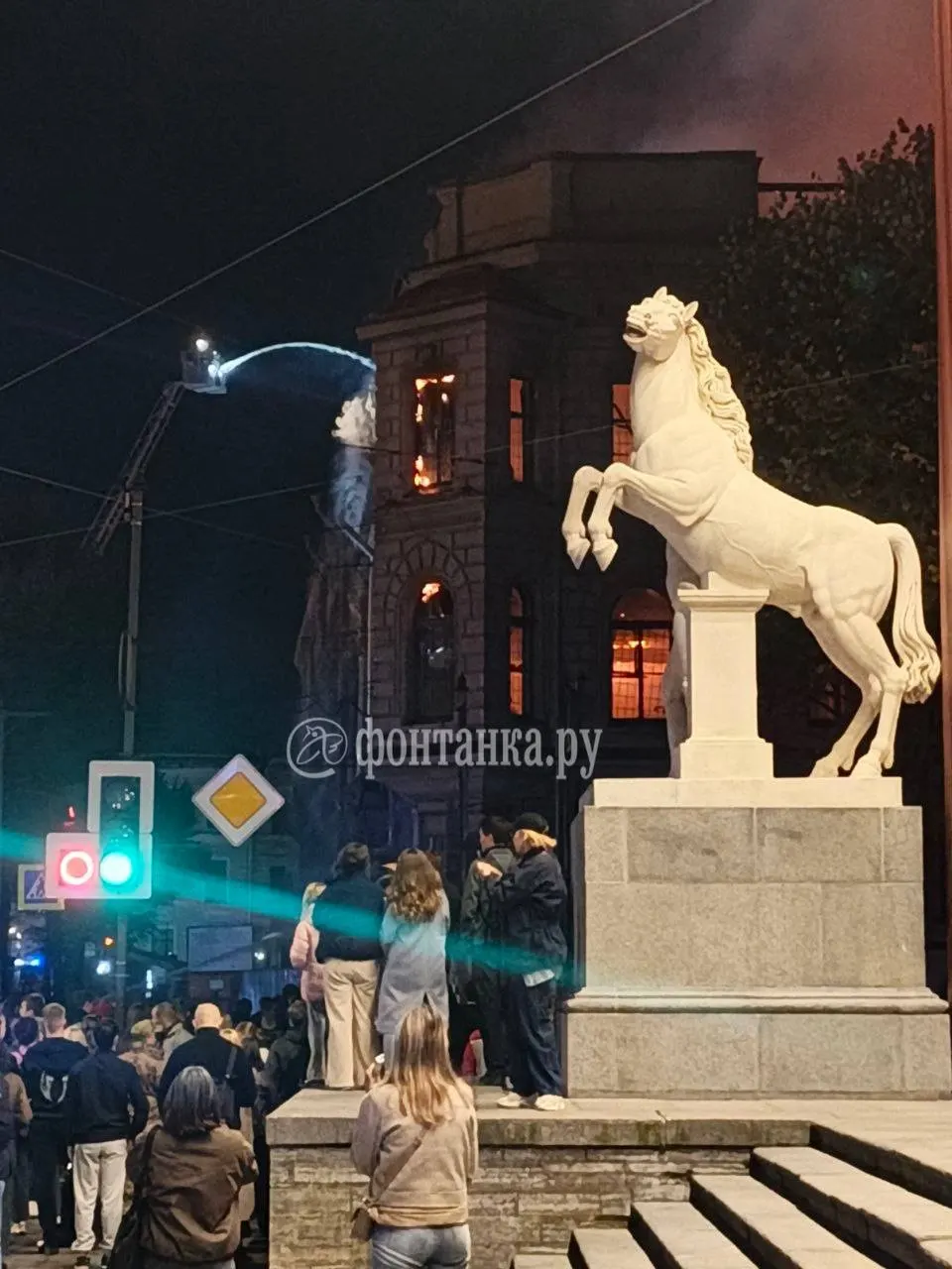 Пожар в городе: пожарные используют вышку для тушения пылающего здания.